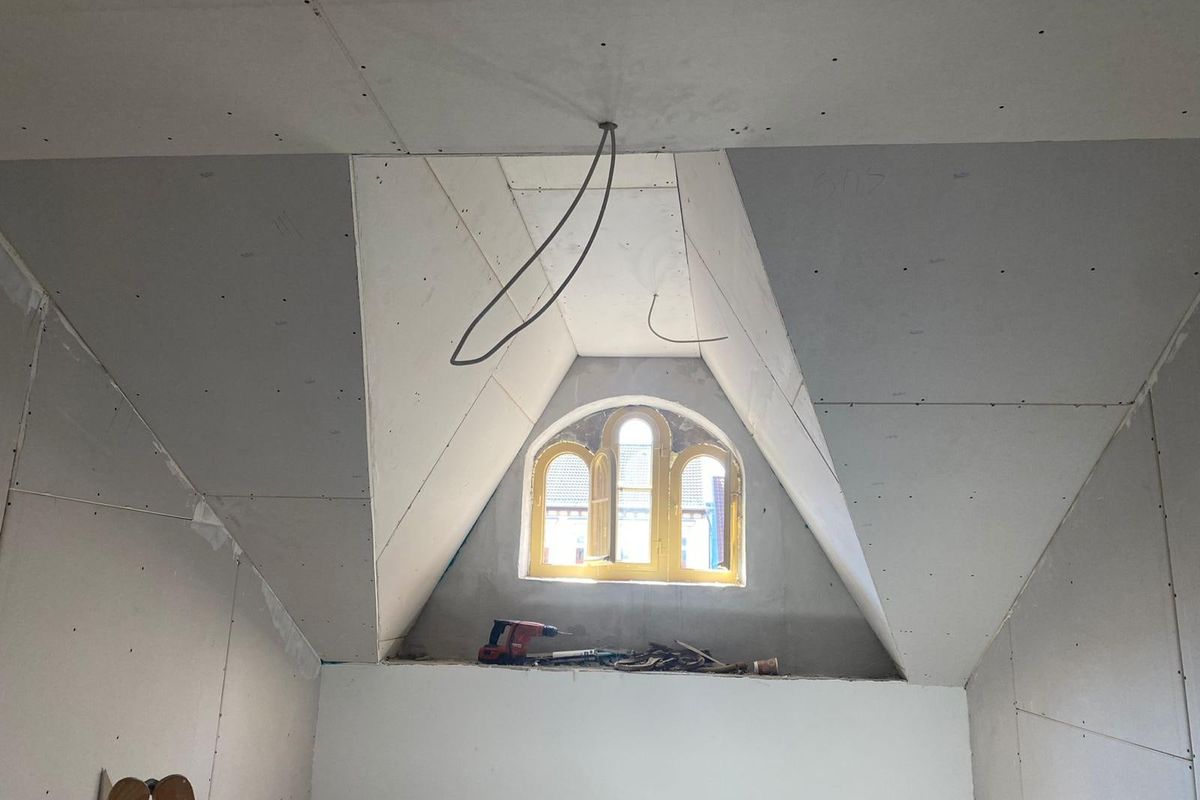 Dachgeschoss mit beplankten Dachschrägen und Gaube mit Rundbogenfenster