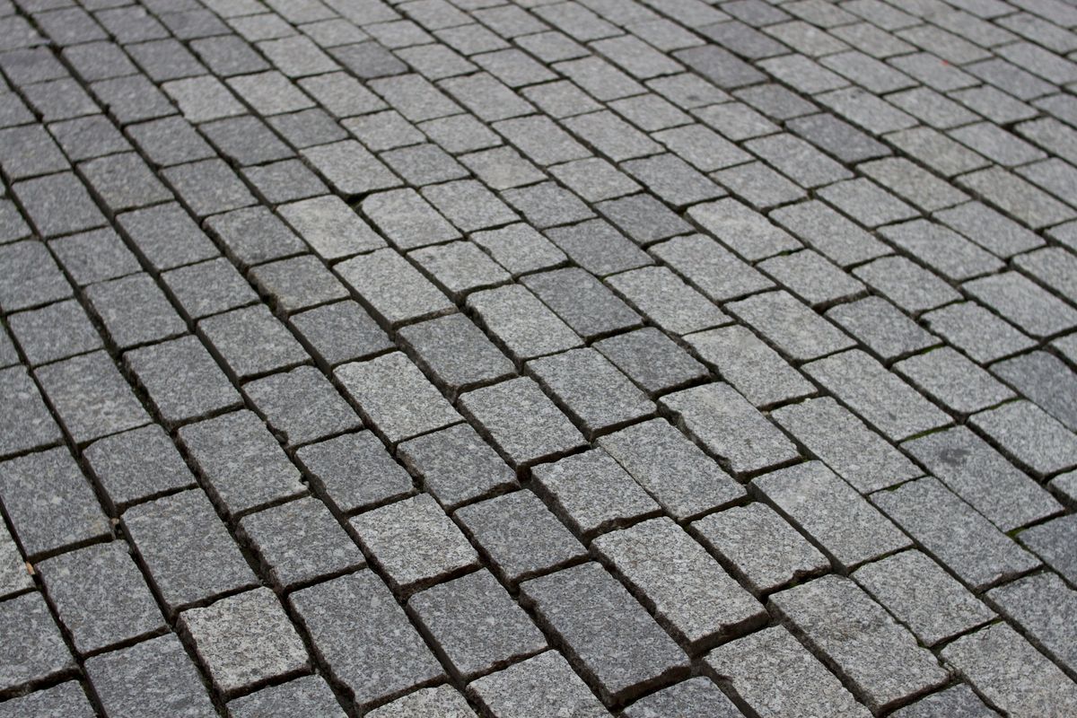 Gleichmäßig verlegtes graues Granitpflaster in Reihen